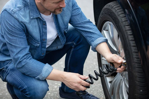Man,Checking,Tyre,Pressure,On,His,Car